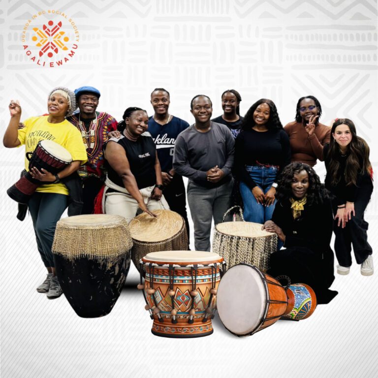A number of people standing around African drums and smiling