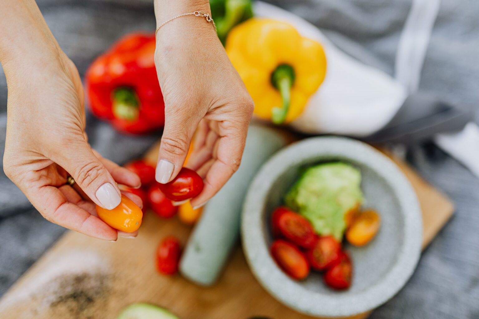 A pair of hands prepares fresh vegetables