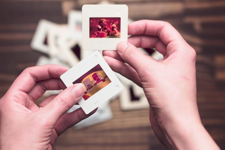 A person holds slides in their hands.