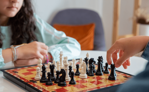 Two children face off in a game of chess. 